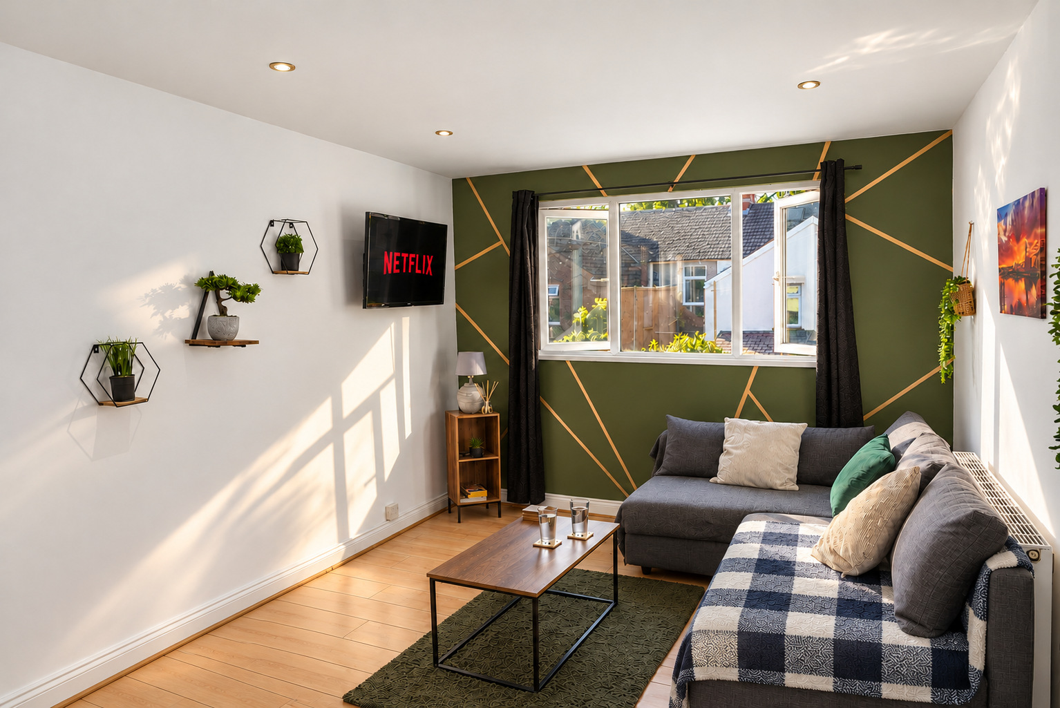 A sunlit apartment living room with an olive feature wall, grey corner sofa and coffee table.