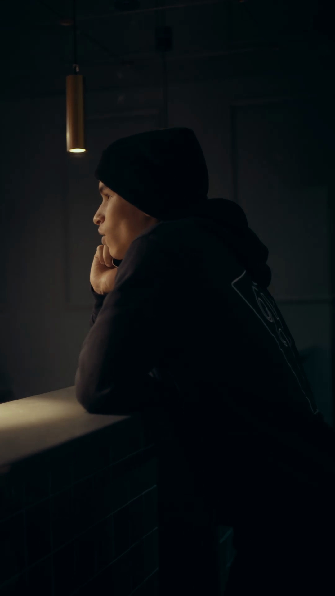A sharp side-profile moment at a counter from our finished fashion film.